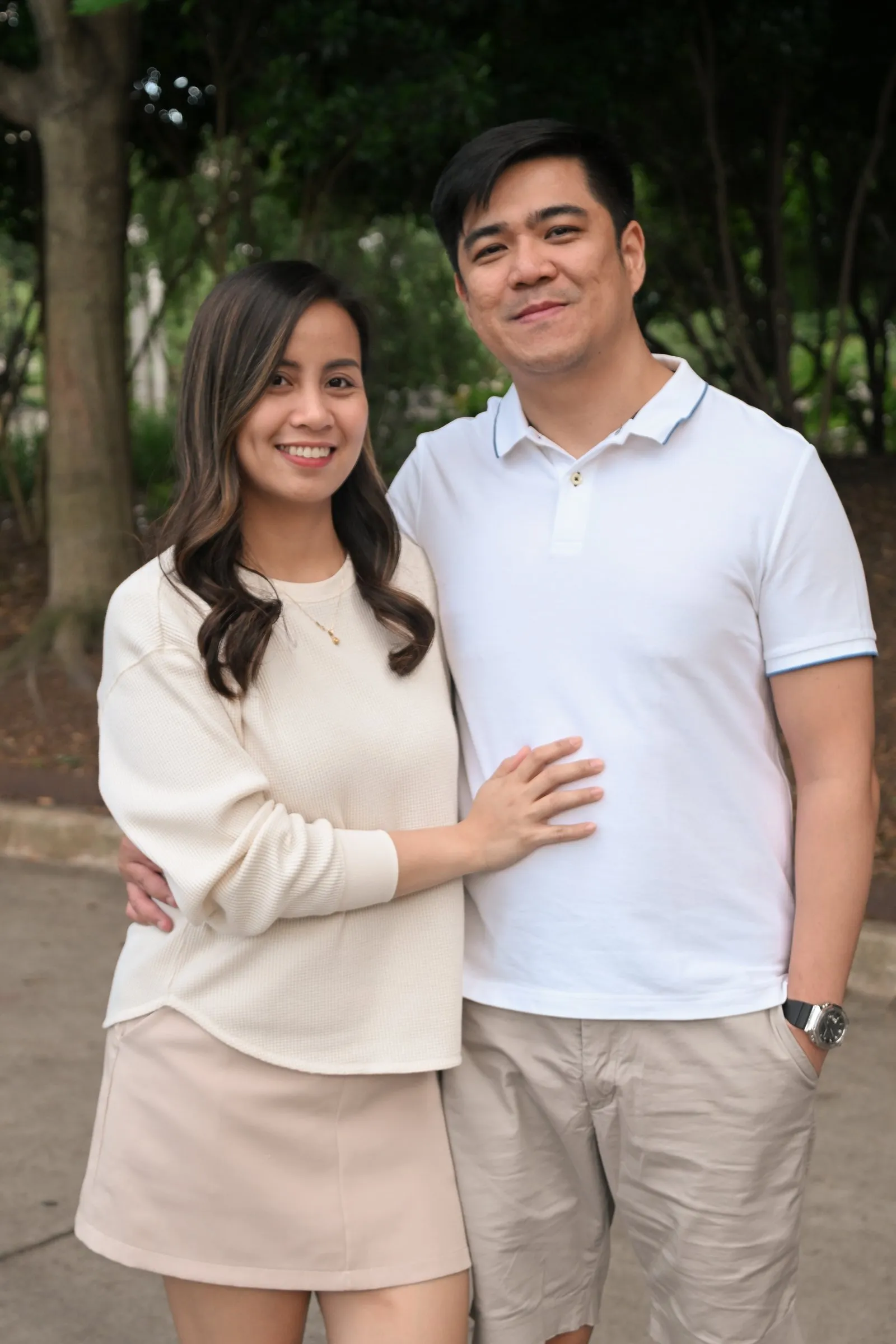 Jessica and Jet smiling, his hand in his pocket and her arm around him