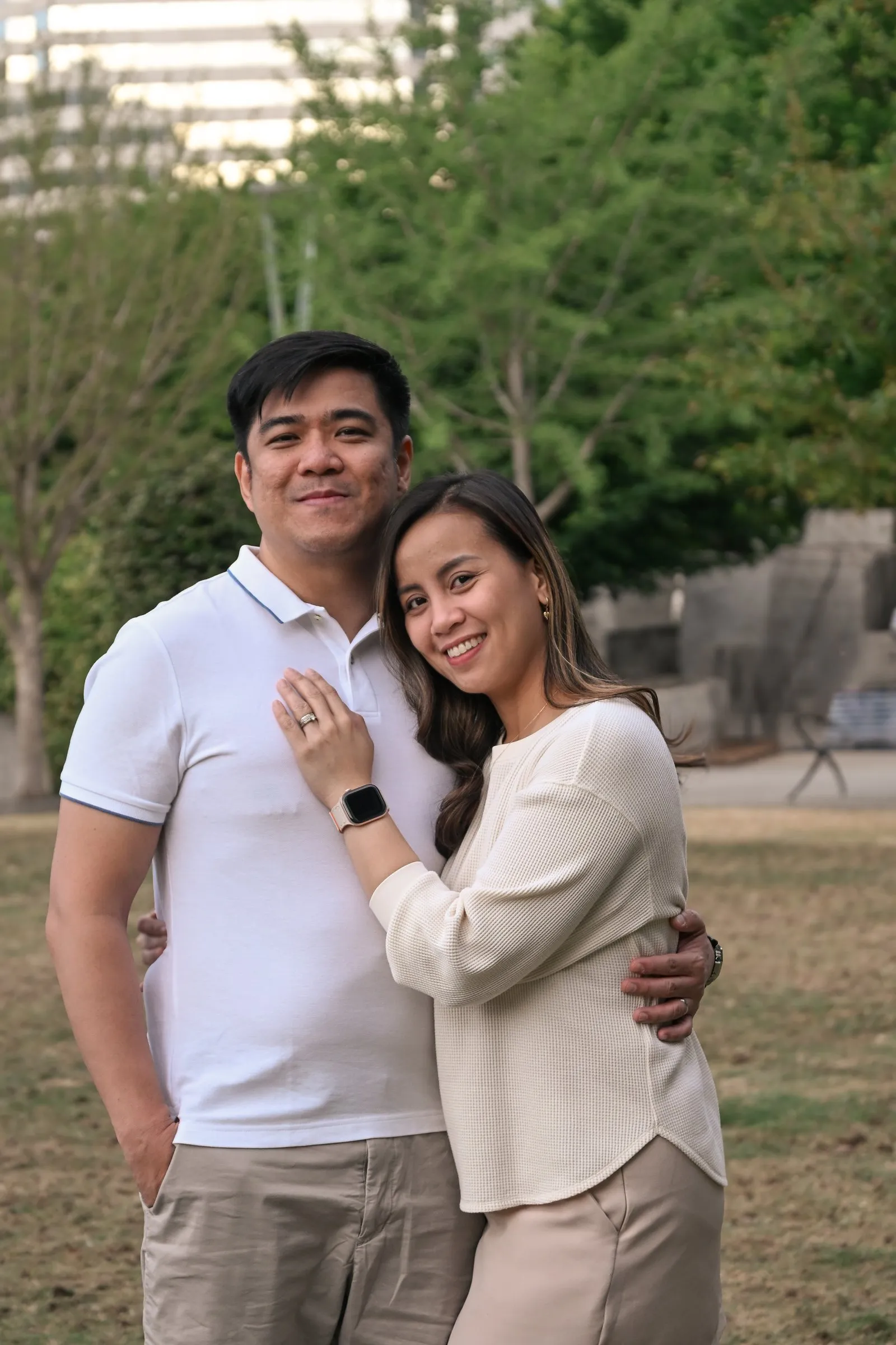 Jessica and Jet embracing on the lawn with the stone walls behind them
