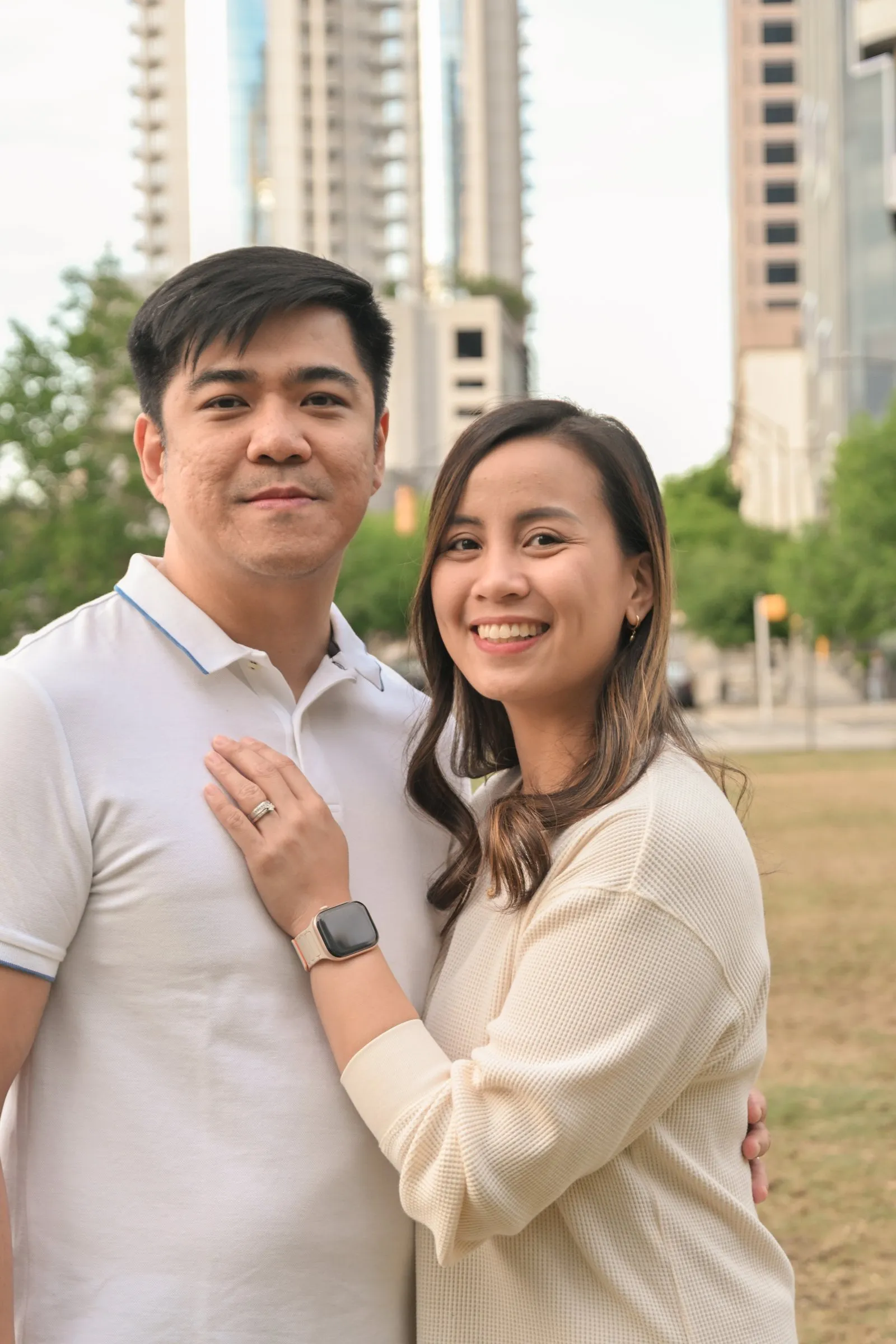 Jessica and Jet close together with the Uptown towers behind them