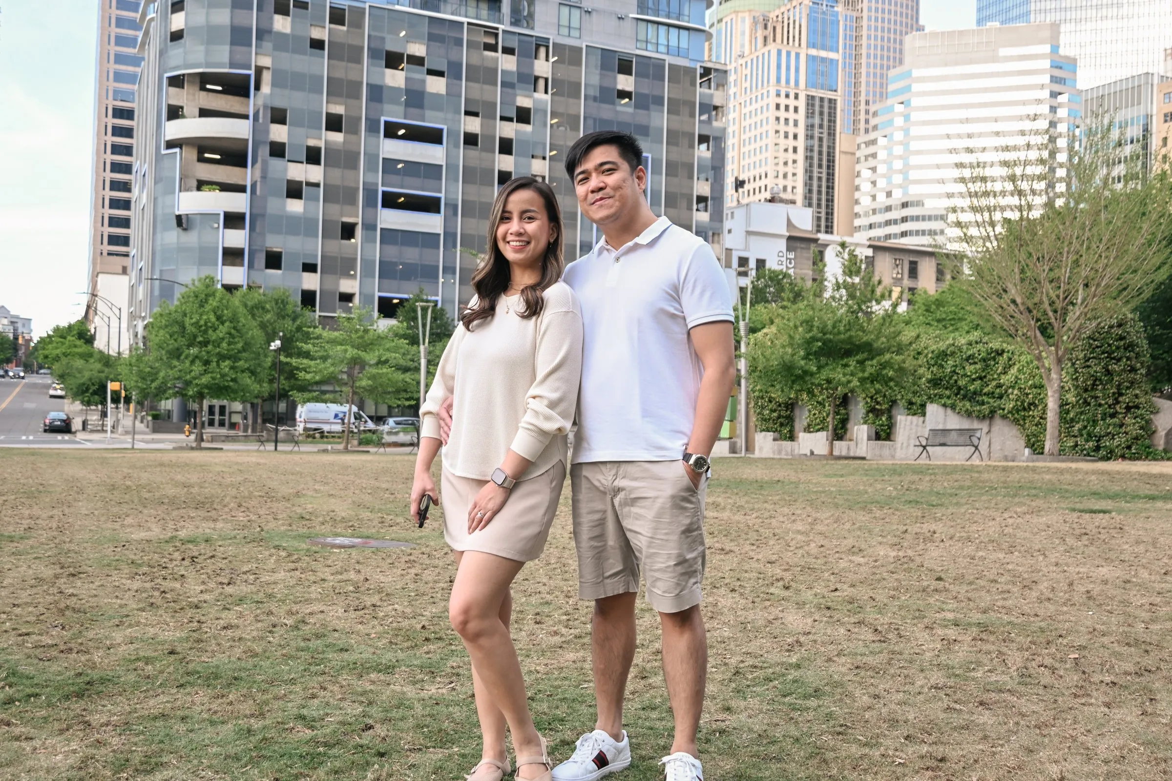 Jessica and Jet on the lawn in front of the Uptown Charlotte towers