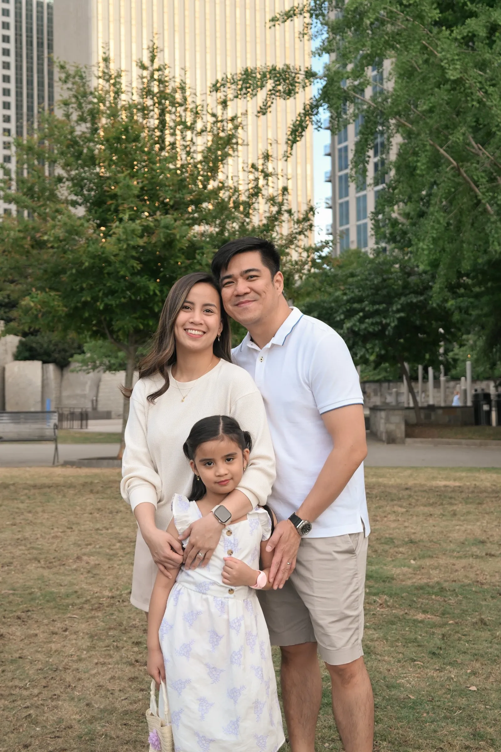 Family portrait on the lawn with Uptown towers behind them