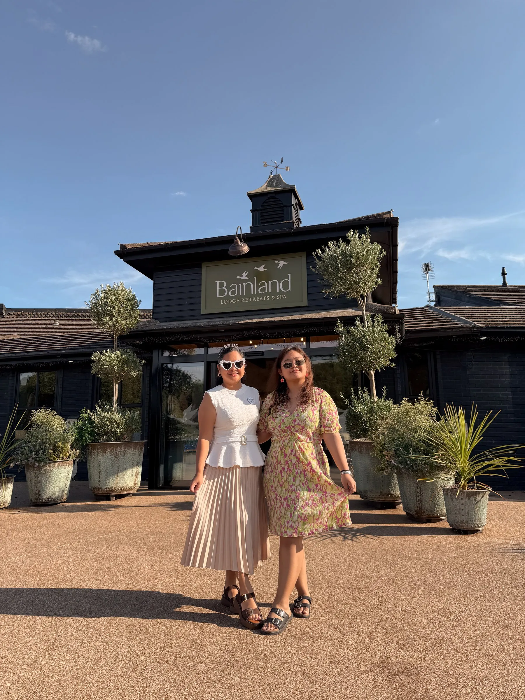 Mathelle and a friend posing in front of Bainland Lodge Retreats