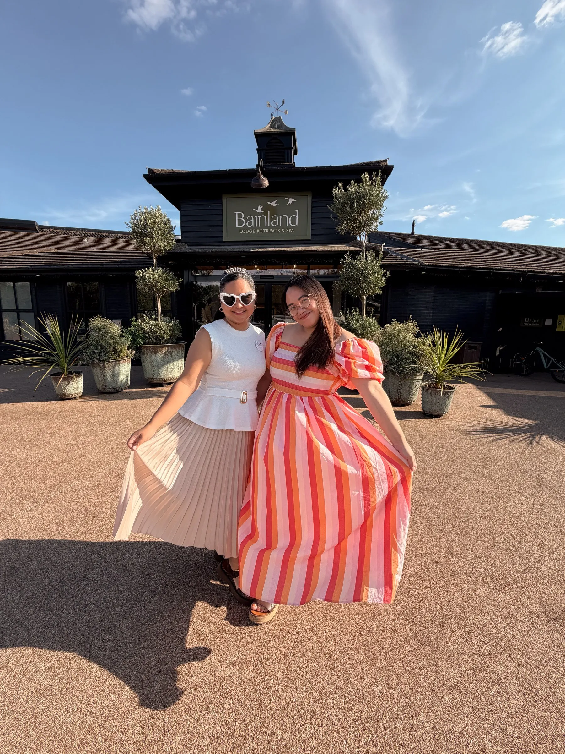 Mathelle and a friend in a striped dress posing outside the lodge