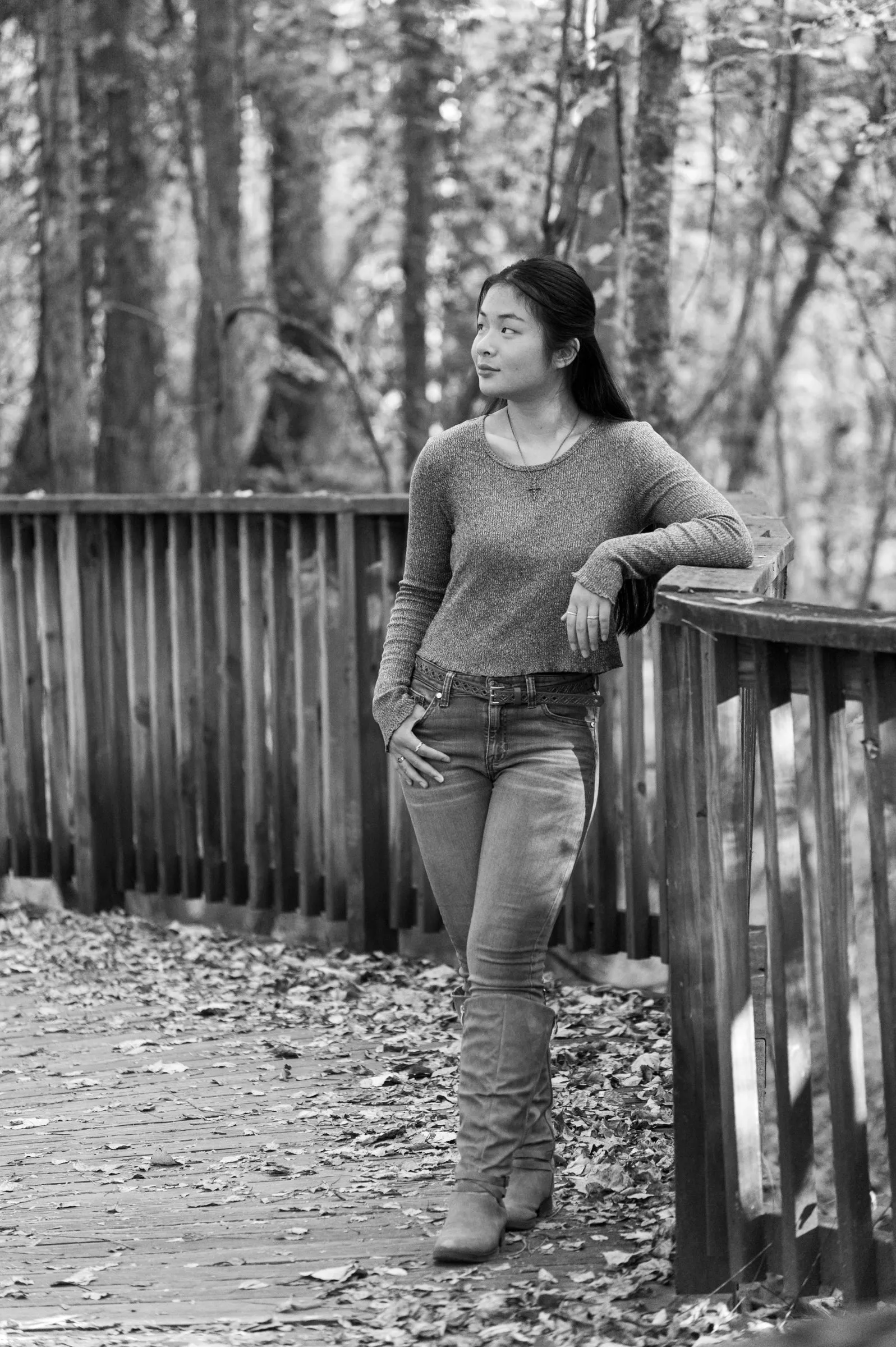 Black and white portrait of Meilin leaning on the boardwalk railing, looking over her shoulder