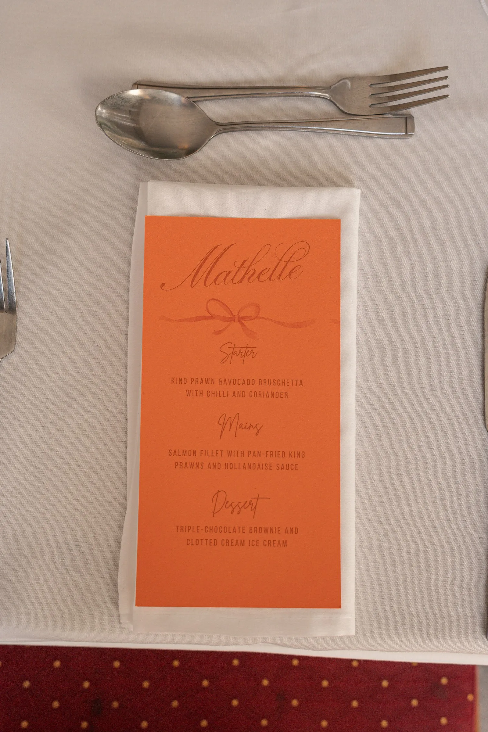 Close-up of a peach menu card at Mathelle's place setting