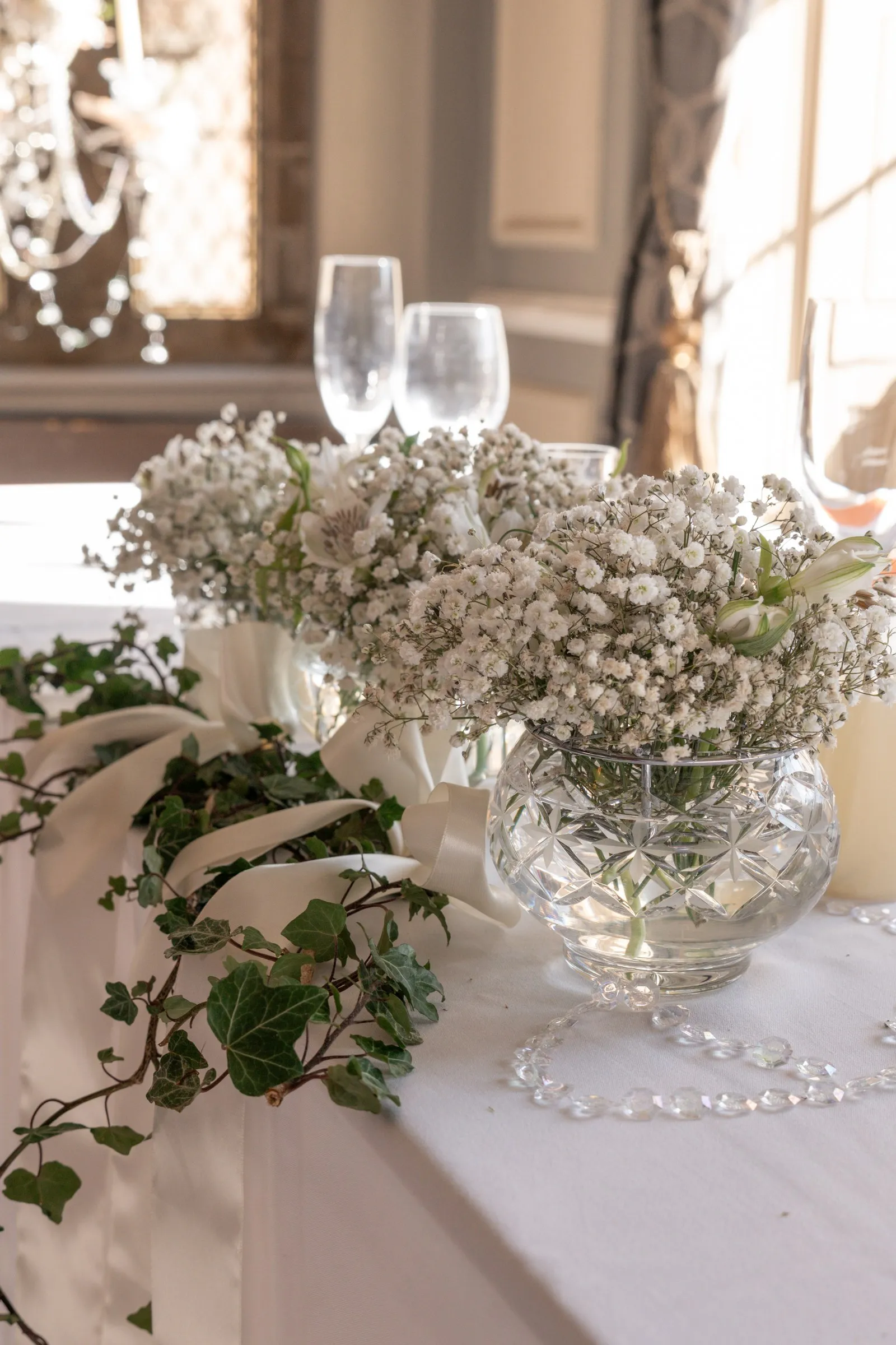 Baby's breath and trailing ivy in a crystal bowl on the head table