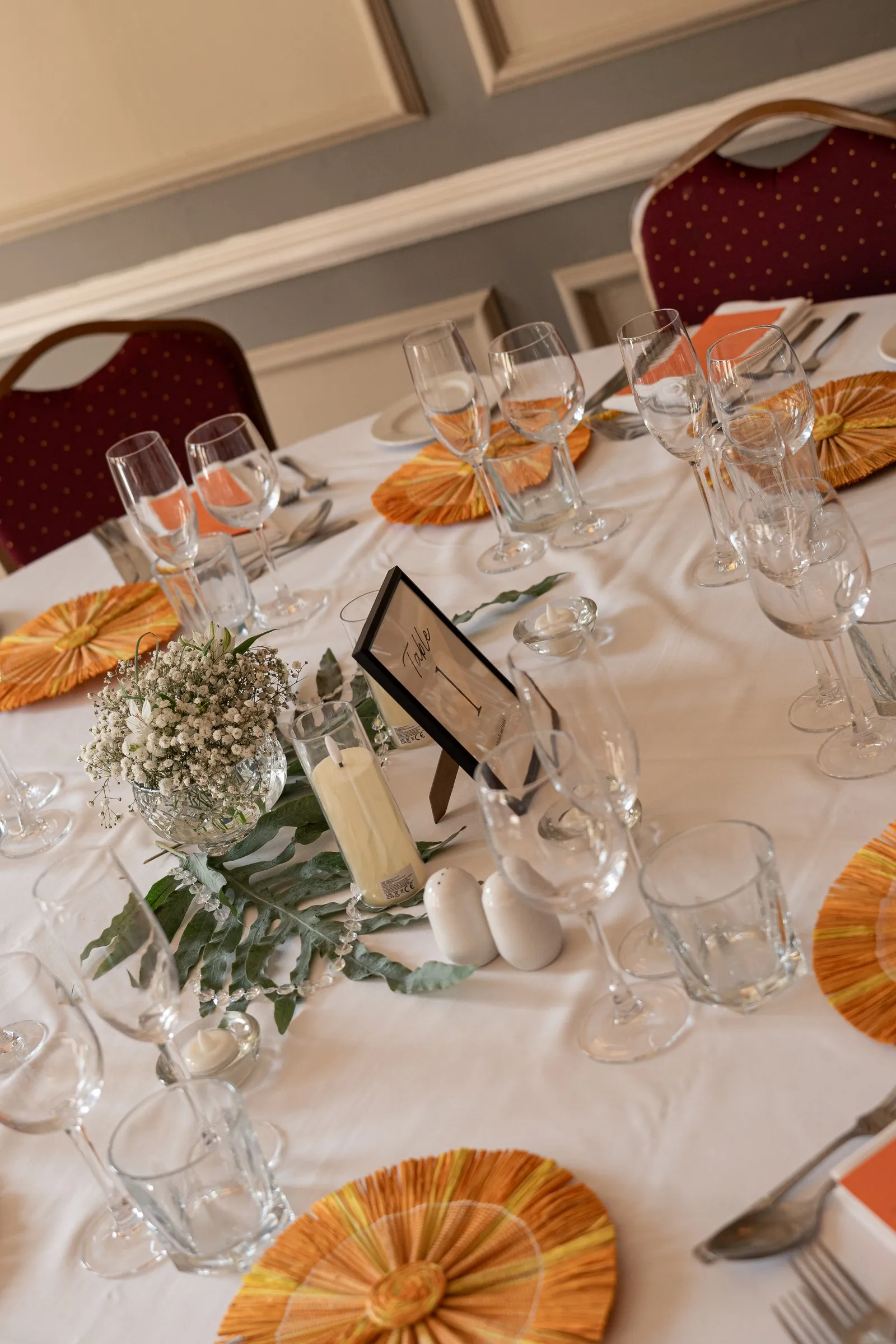 Round reception table set with peach fans, baby's breath and crystal glasses
