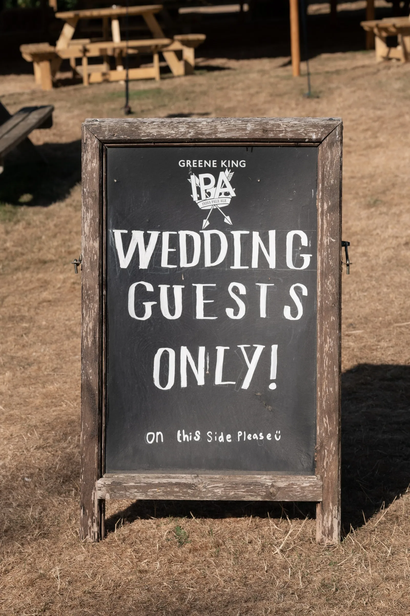 Chalkboard sign reading Wedding Guests Only on the lawn