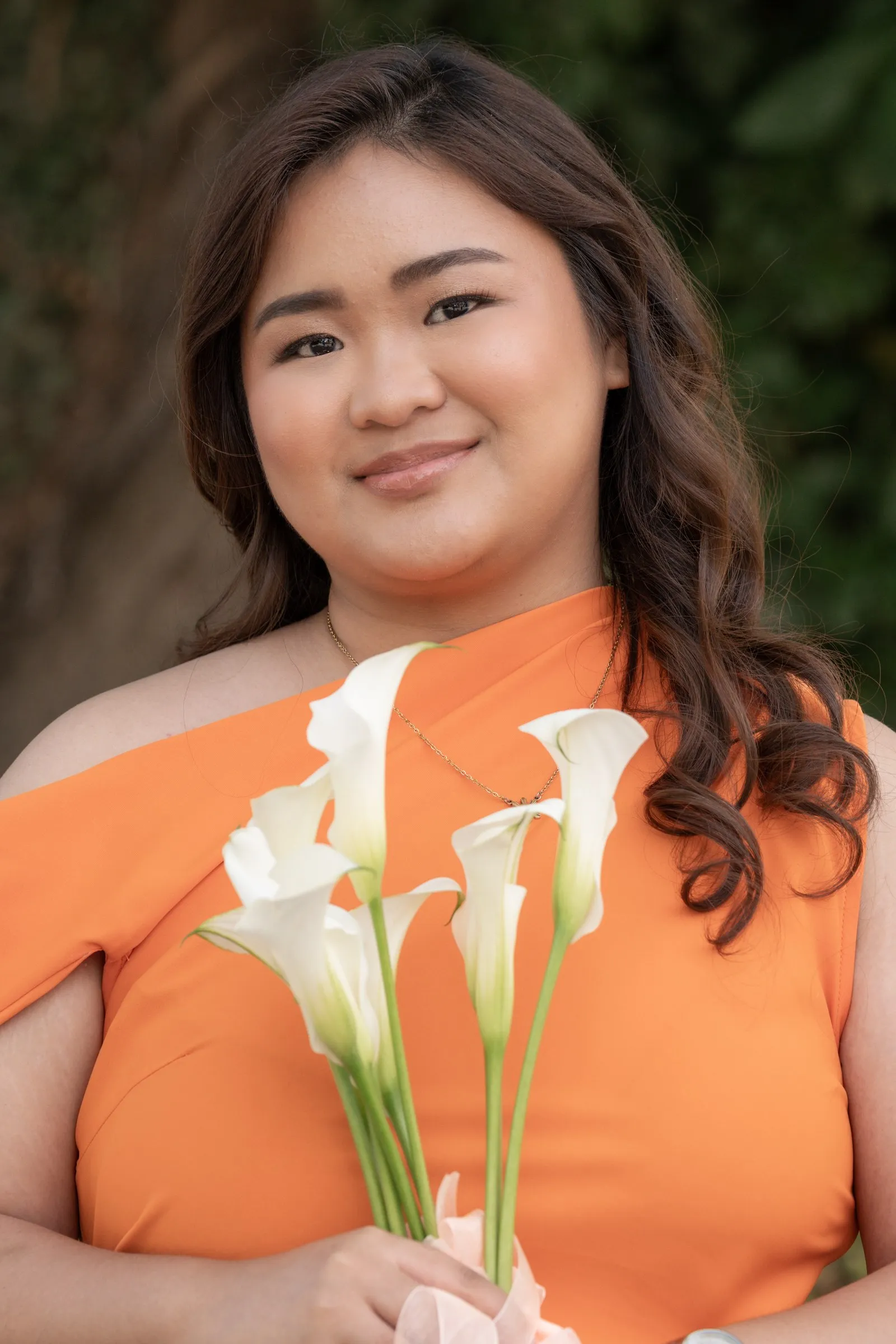 Close portrait of a bridesmaid in peach with calla lilies