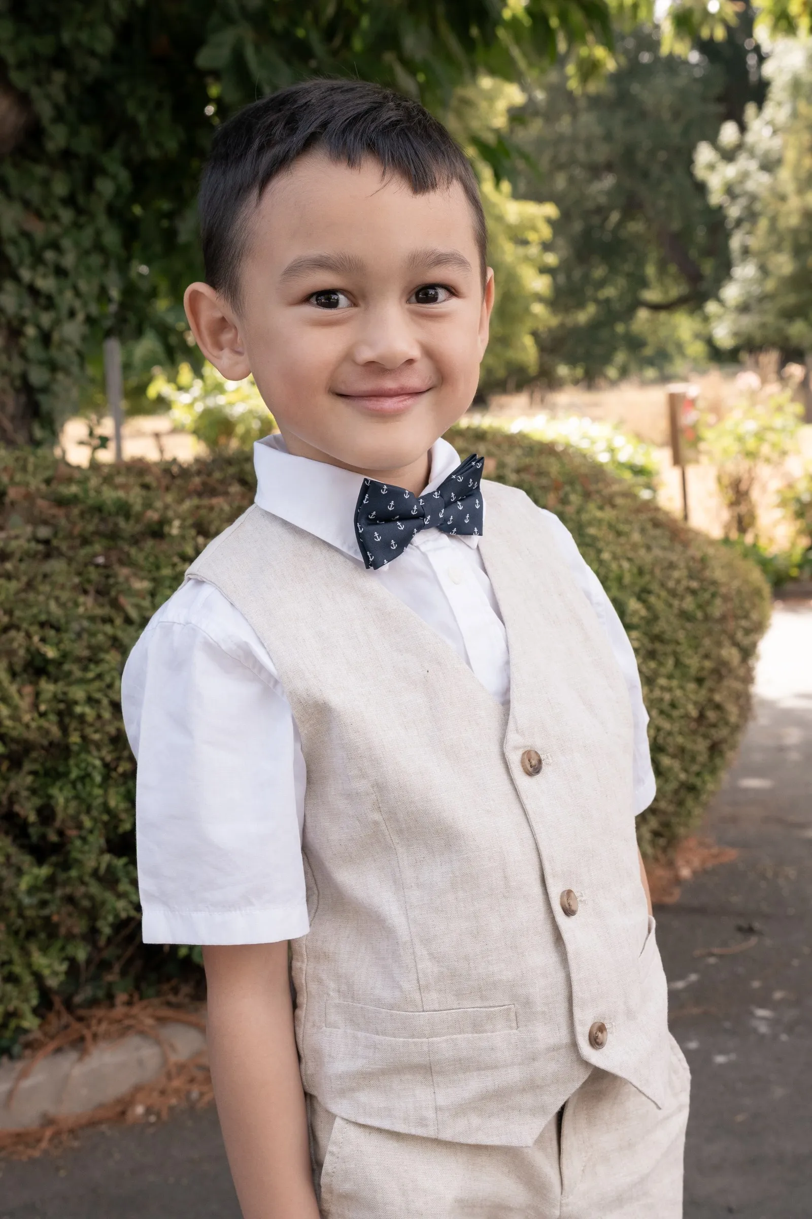 Mathelle's son smiling in his linen vest and bow tie