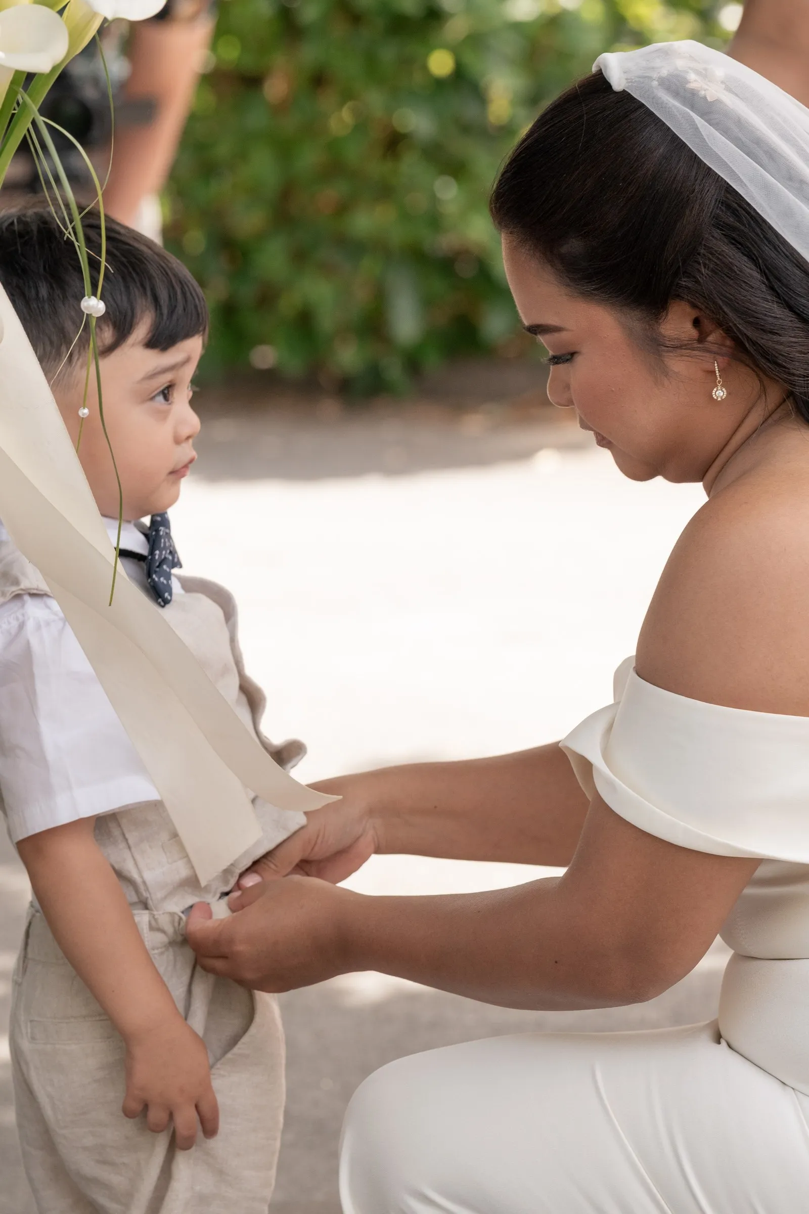 Mathelle kneeling to fix her son's outfit