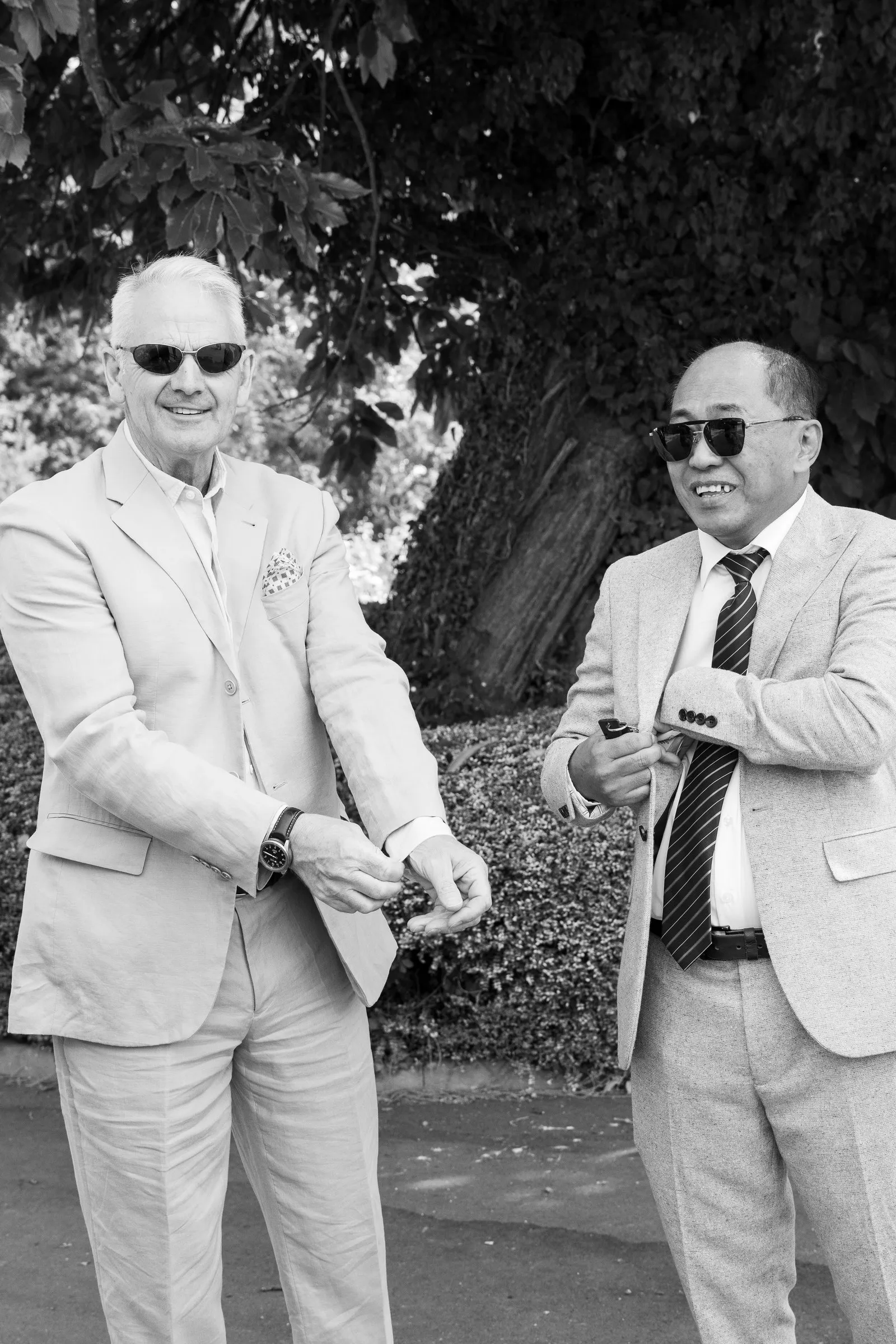 Black and white frame of two guests in cream suits