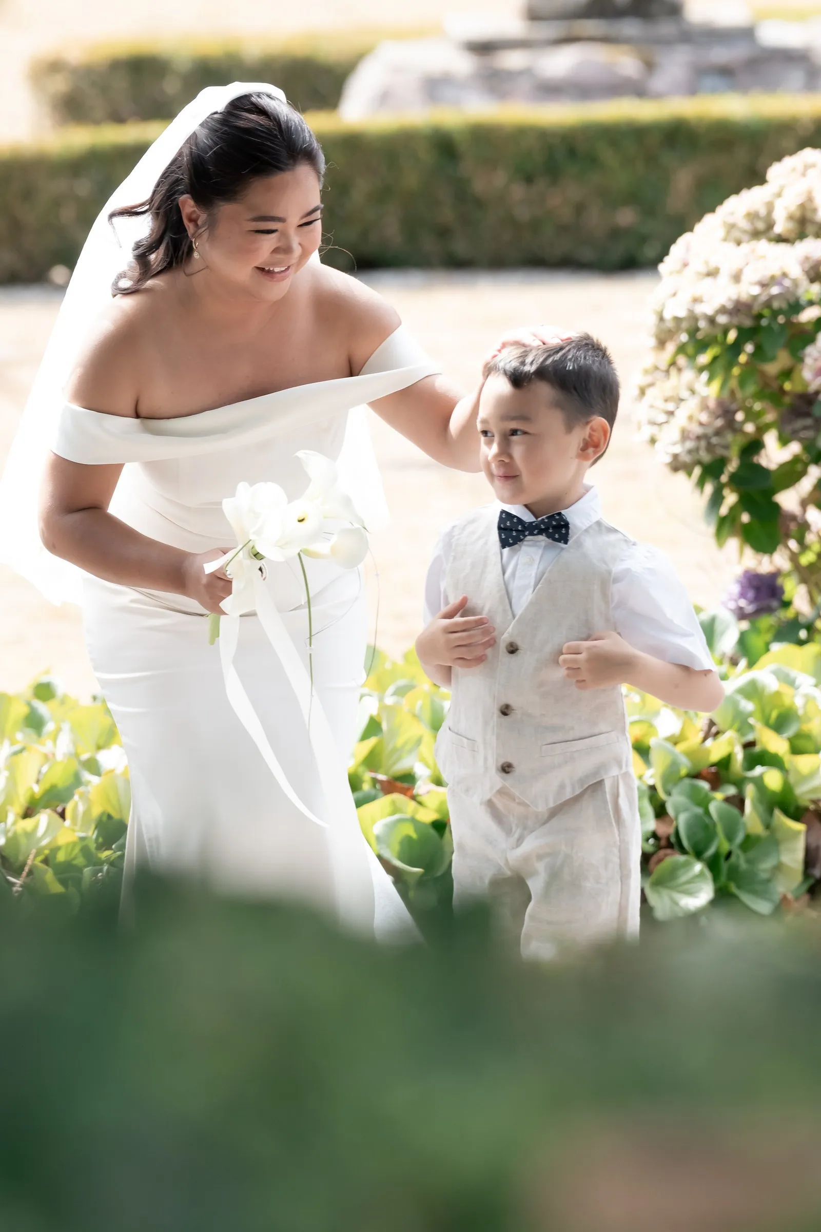 Mathelle smiling down at her son as he hands her the bouquet