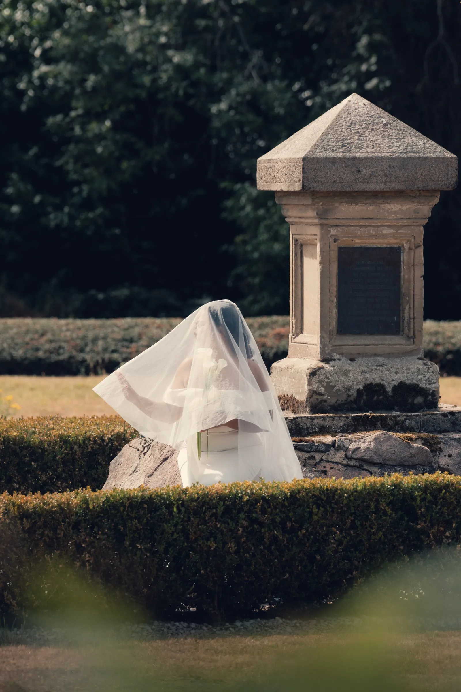 Mathelle beneath her veil among the hedges at Rothley Court