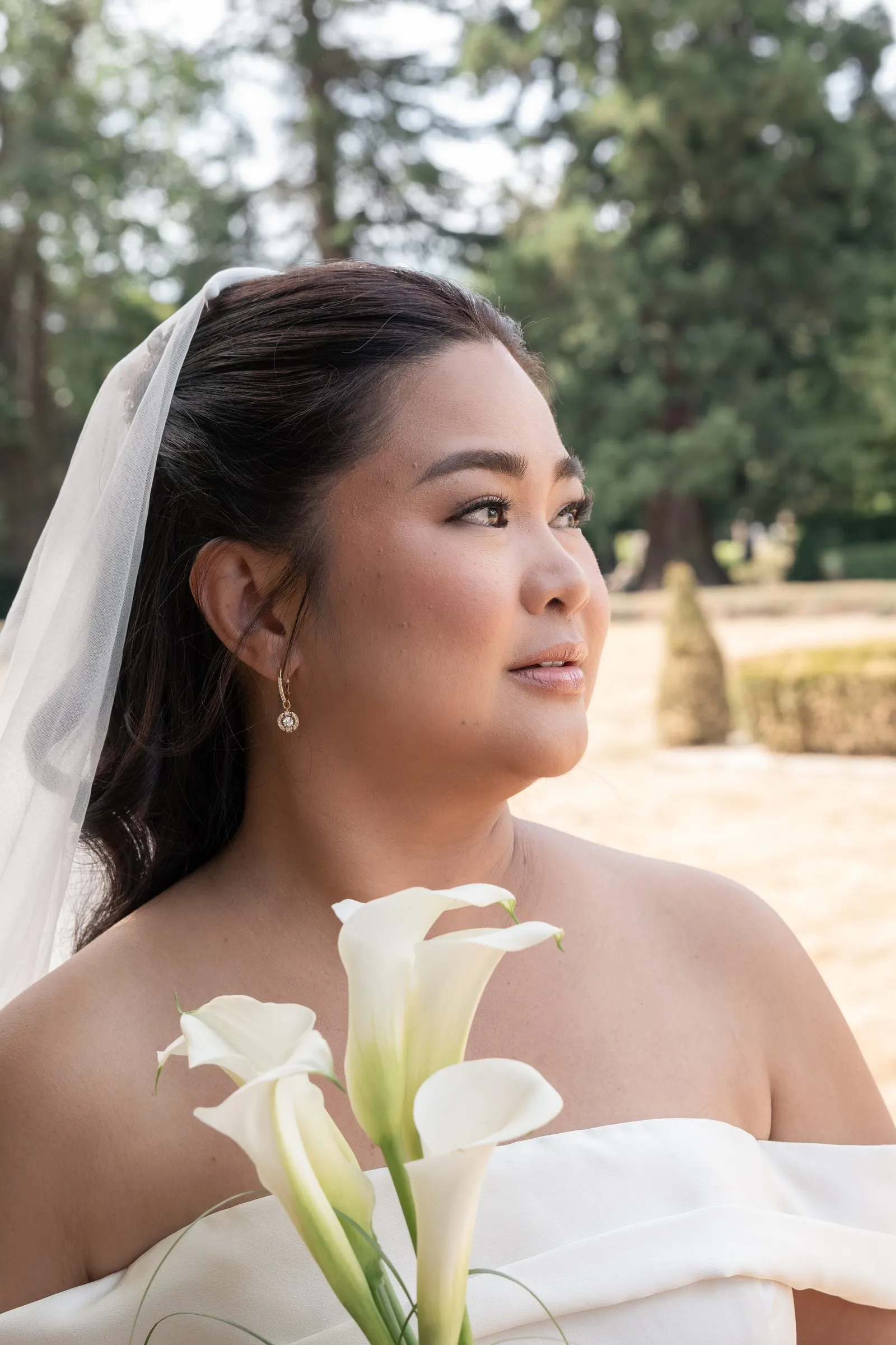 Bridal portrait of Mathelle with calla lilies against the trees