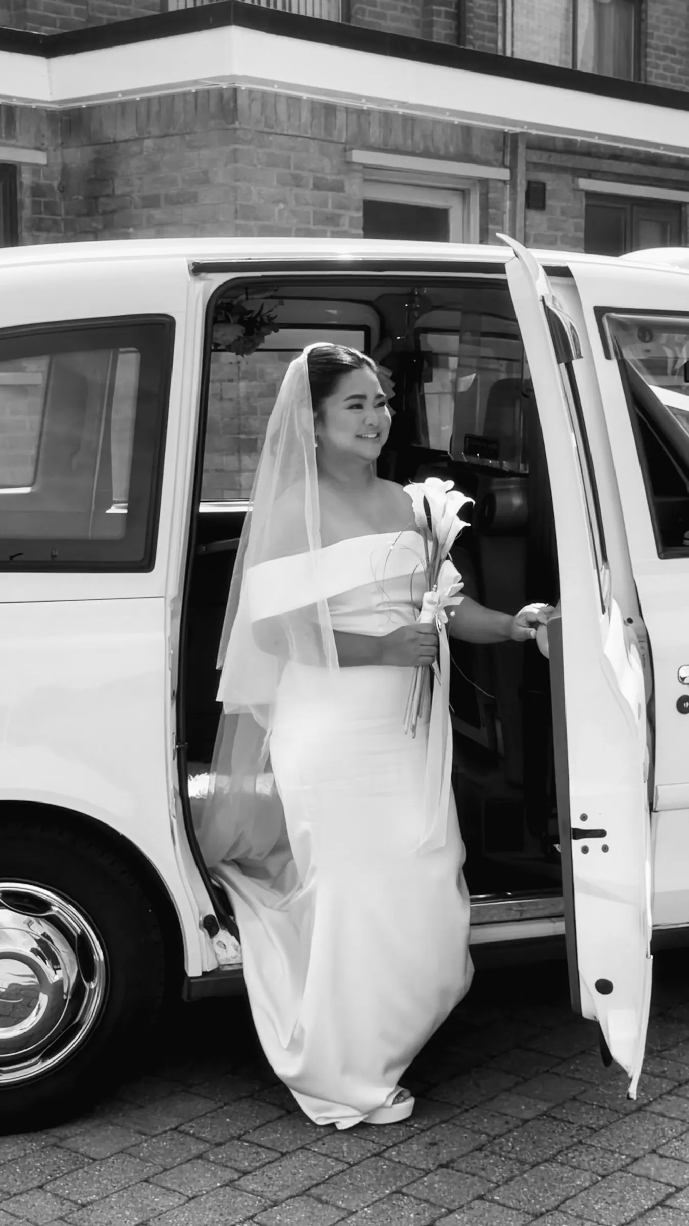 Black and white frame of Mathelle stepping out of the taxi