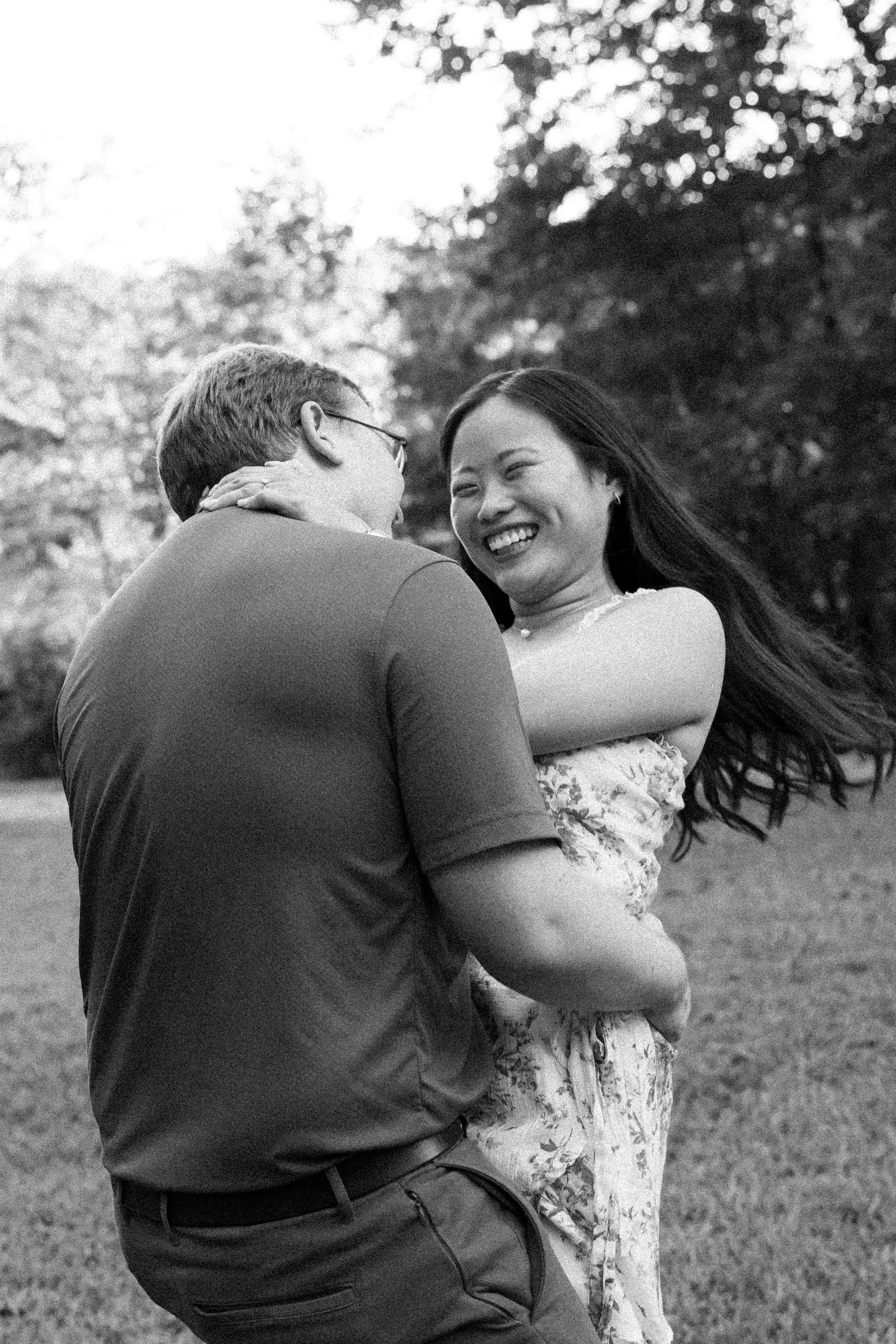 Black and white frame of Mya laughing in Jacob's arms