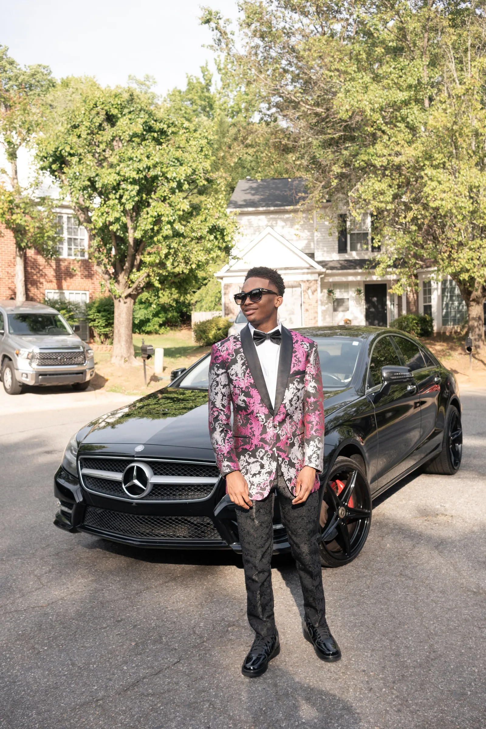 Wide prom portrait in front of the black Mercedes in the street