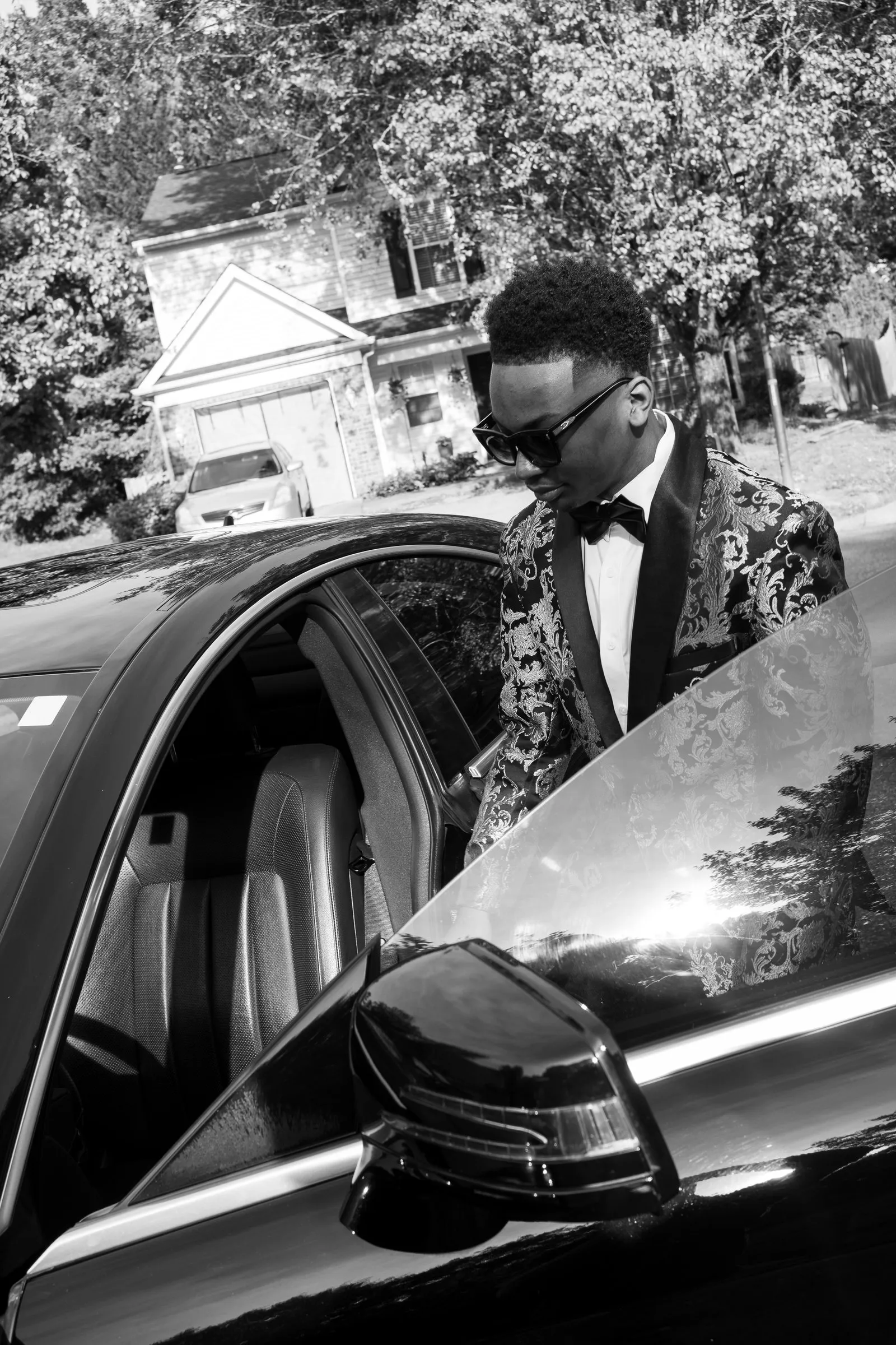 Black and white photograph of him stepping into the Mercedes