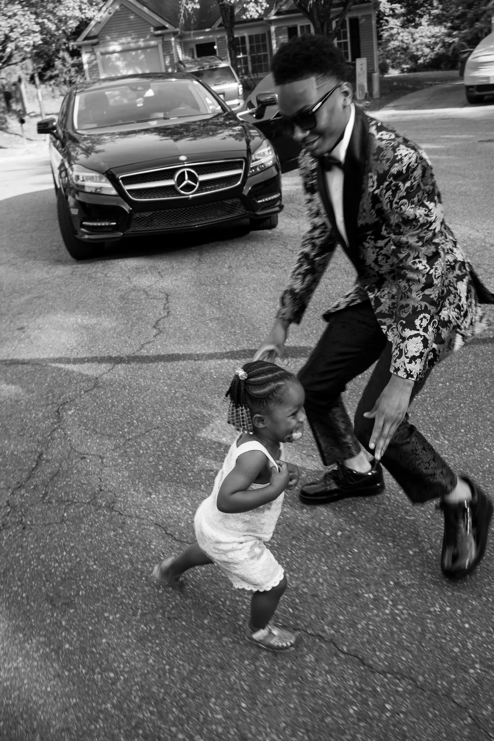 Black and white photograph of him dancing with a toddler in the street