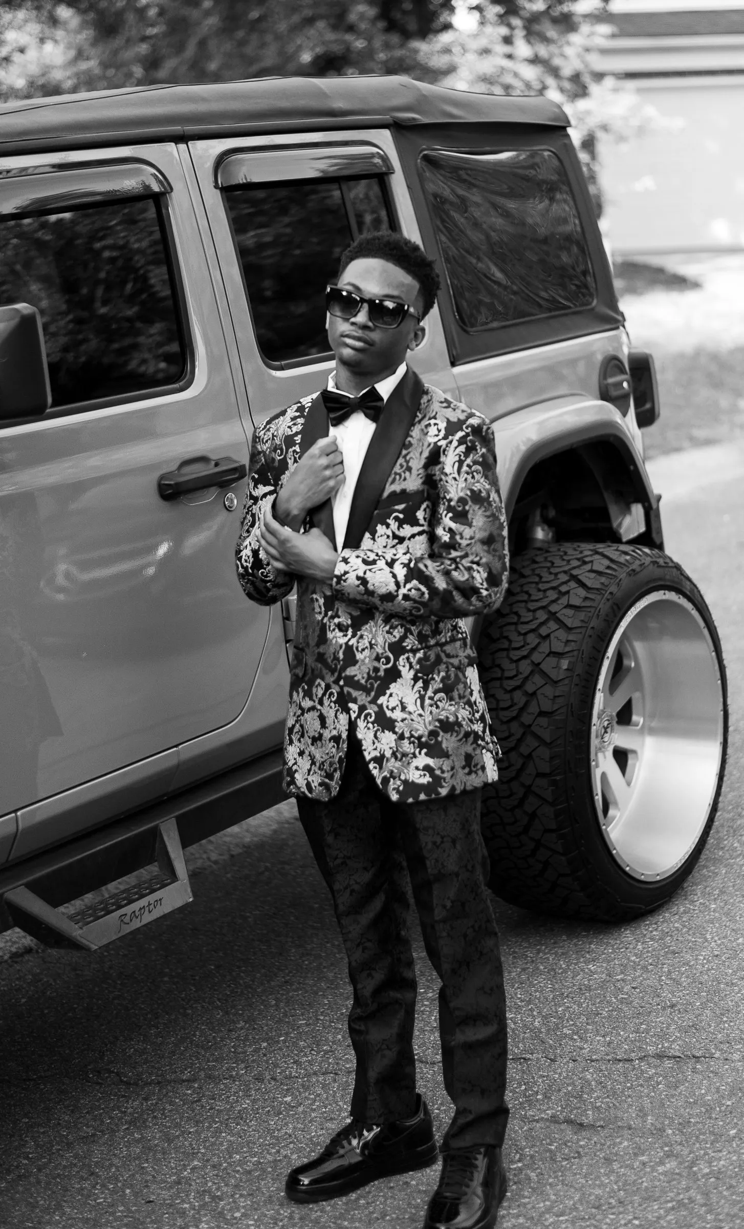 Black and white full length portrait in front of a lifted Jeep Wrangler