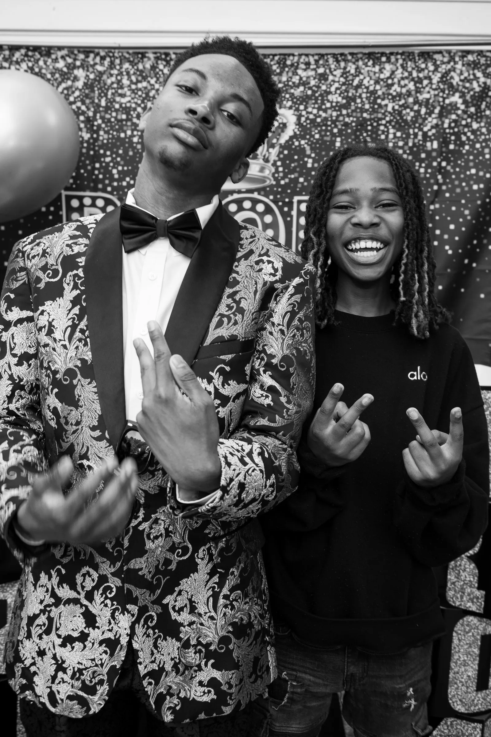 Black and white photograph of him and a young friend throwing up hand signs