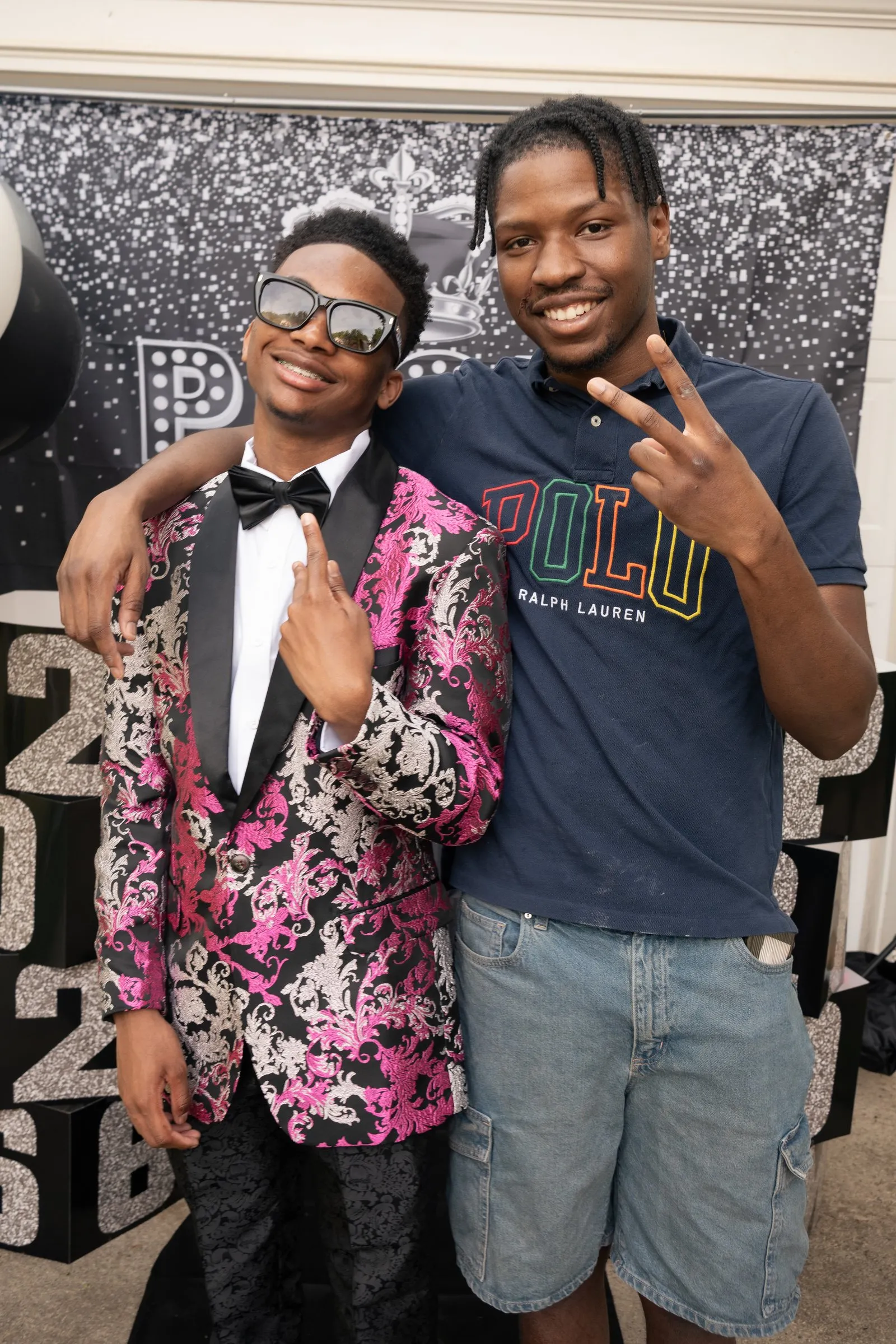 Peace signs with a friend in a navy Polo tee at the backdrop
