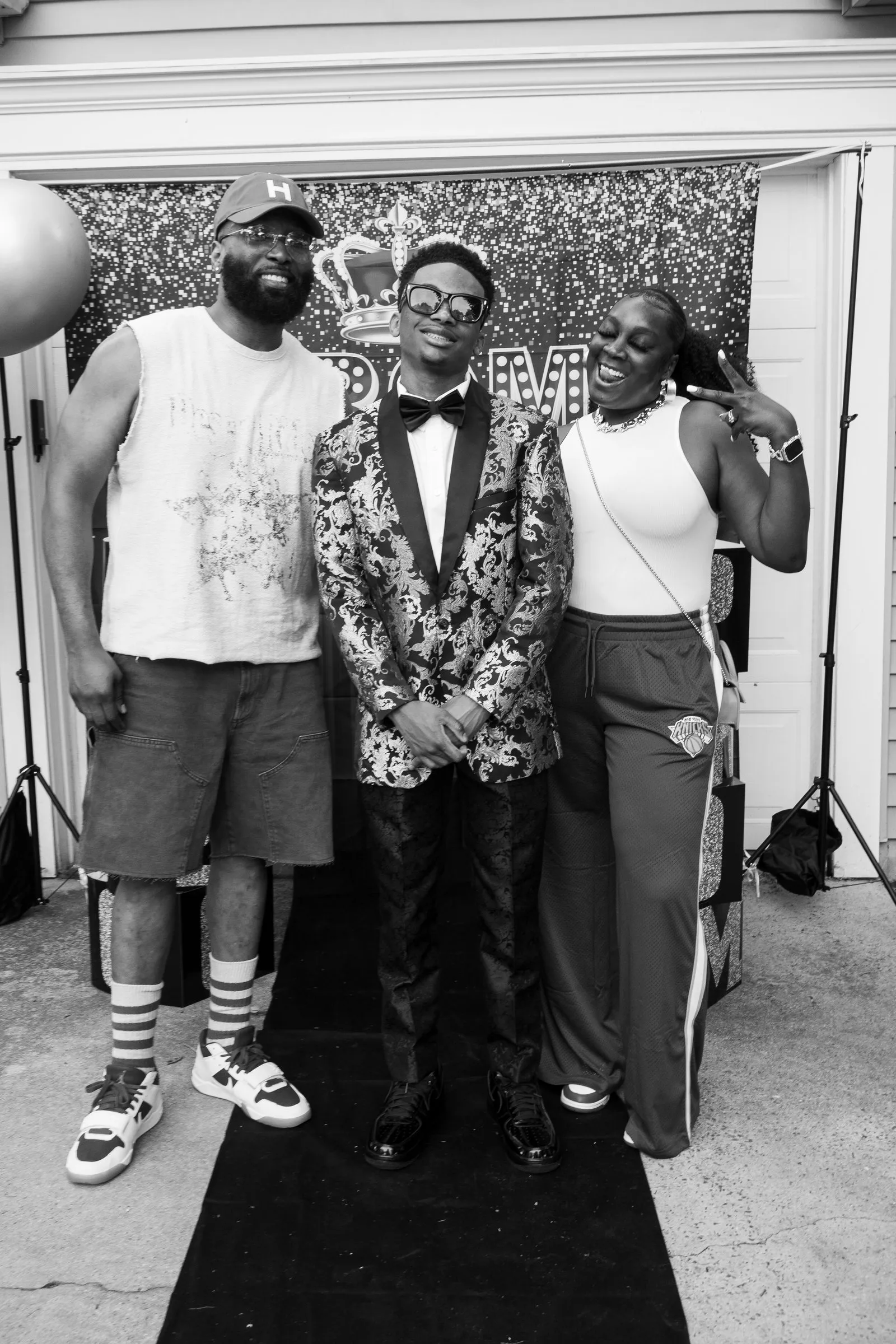 Black and white photograph of him between two family members on the runner