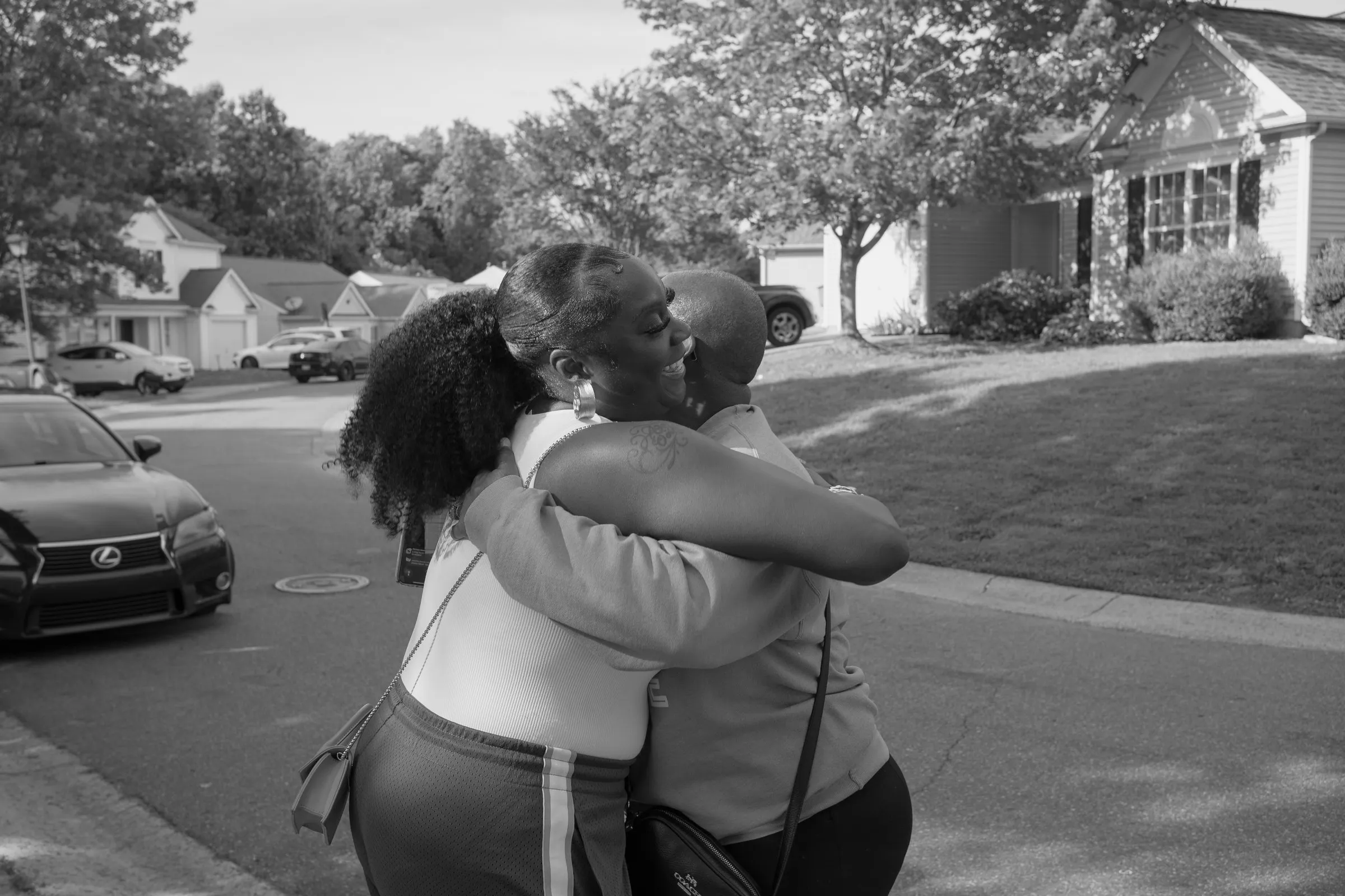 Black and white photograph of a long hug in the street outside the house