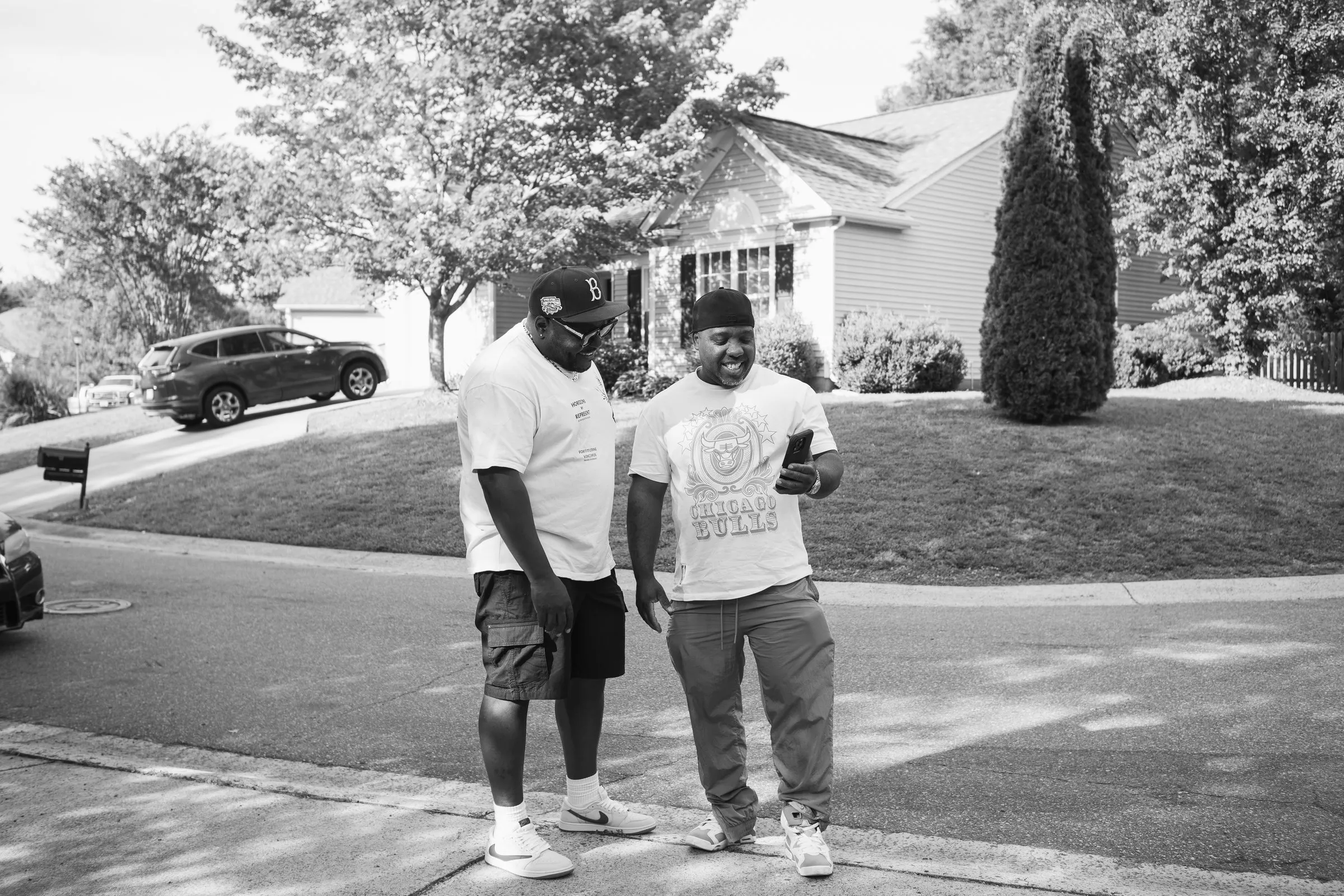Black and white photograph of two men talking in the street before the send-off