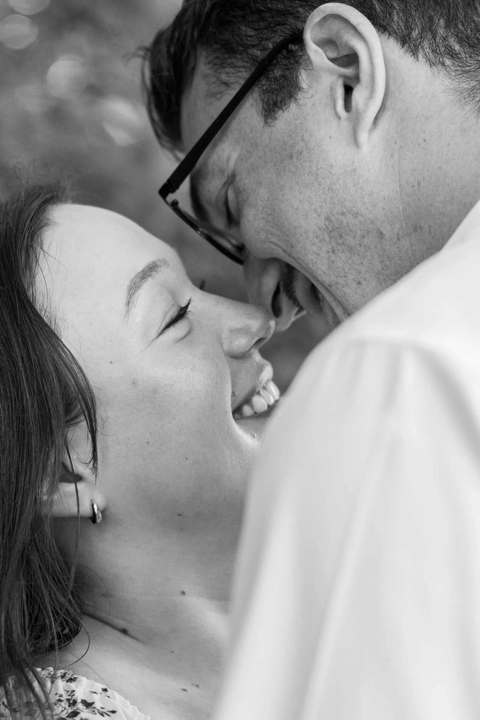 Black and white close-up of Spencer and Kayla nose to nose, both laughing