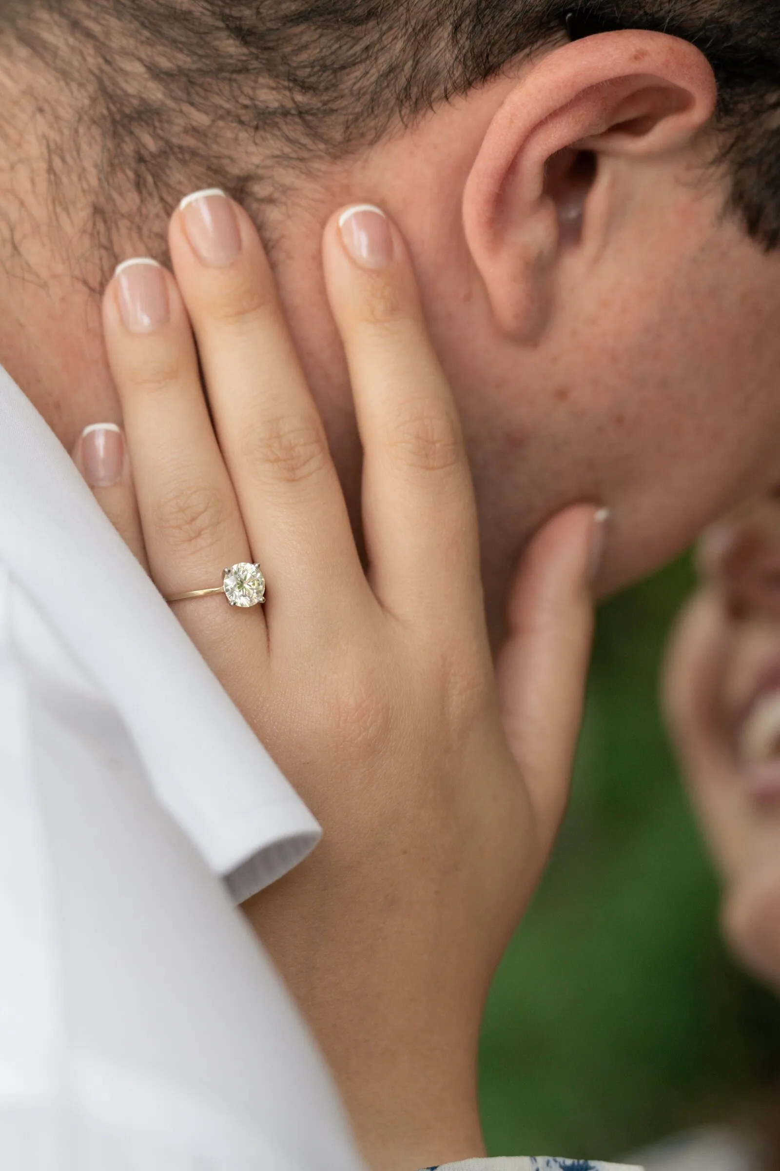 Kayla's hand on Spencer's cheek, her solitaire engagement ring in sharp focus