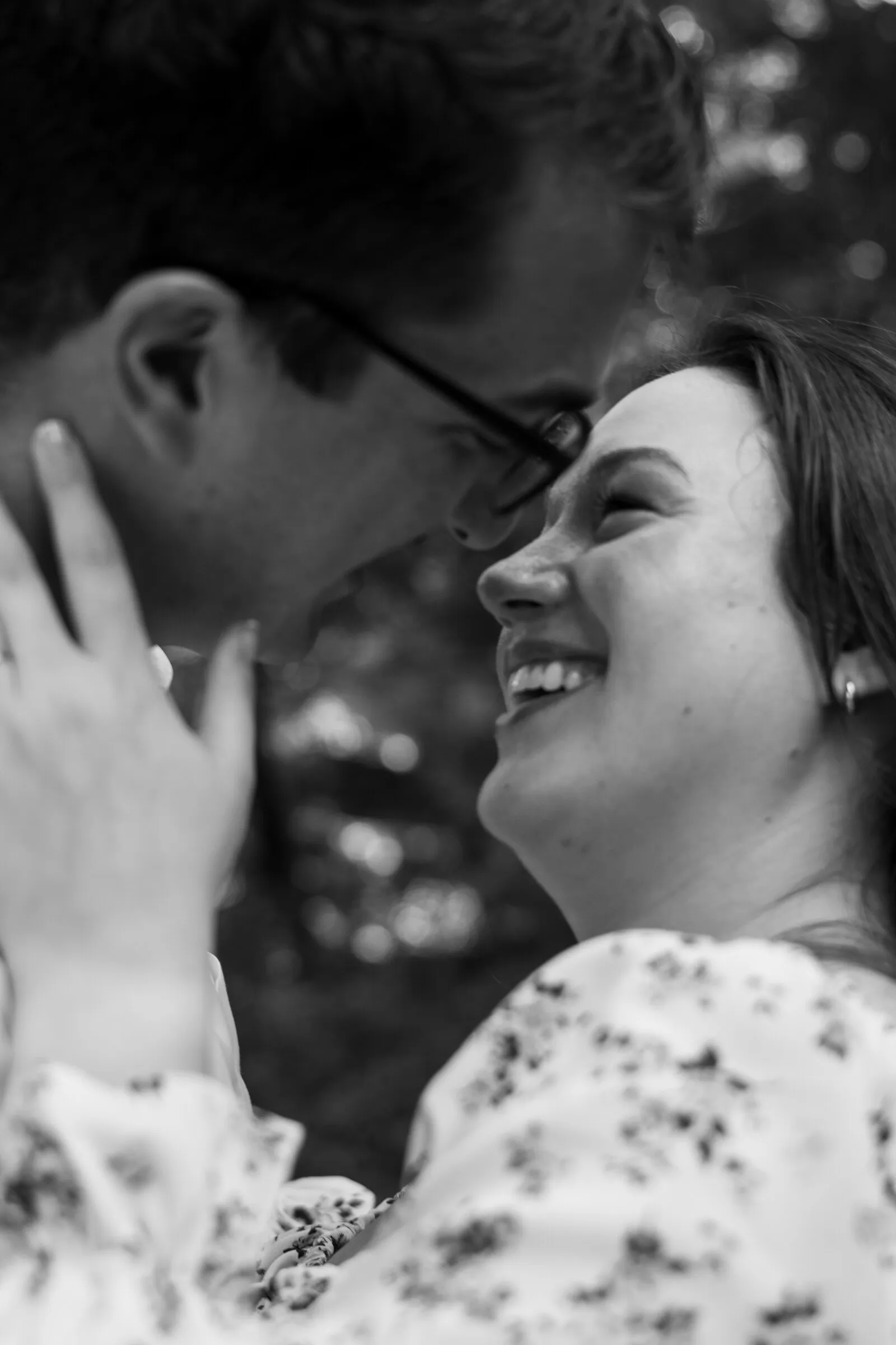 Black and white close-up of Kayla smiling up at Spencer with her hand on his cheek