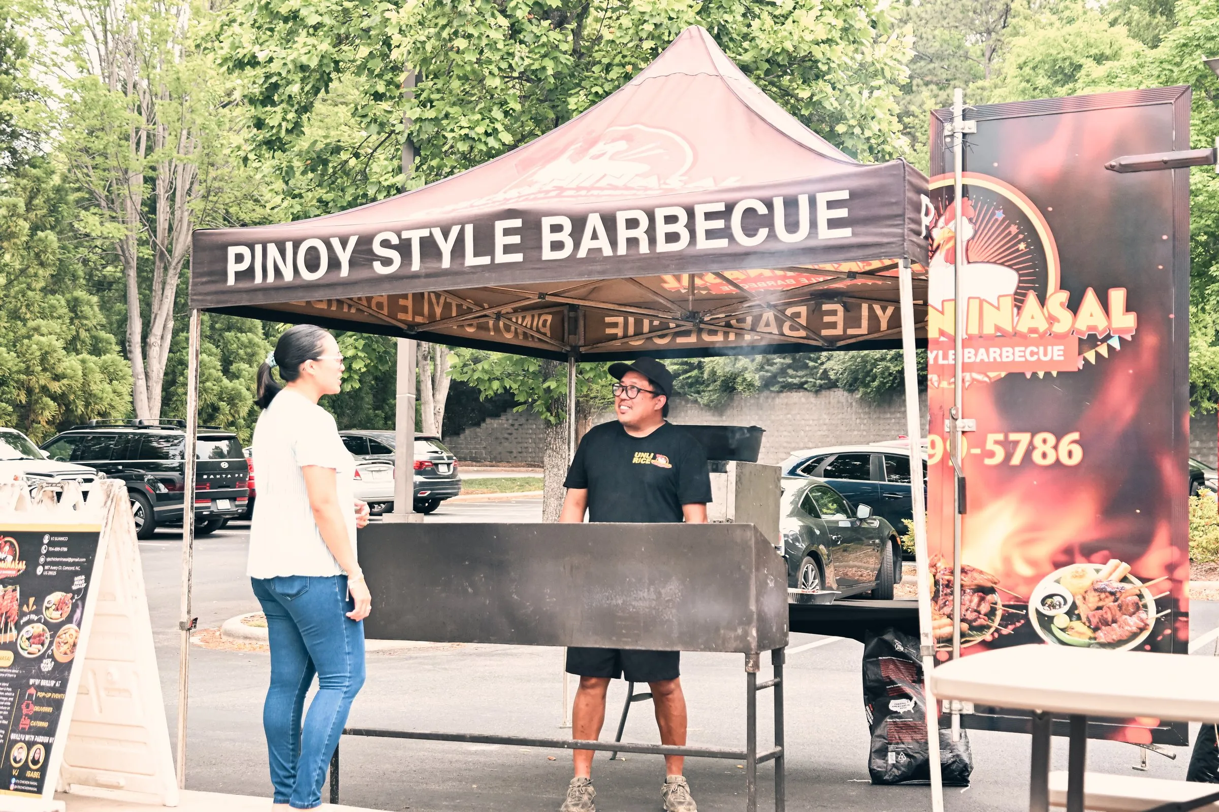 The VJ's Chicken Inasal tent and grill beside the food truck, a customer waiting to order