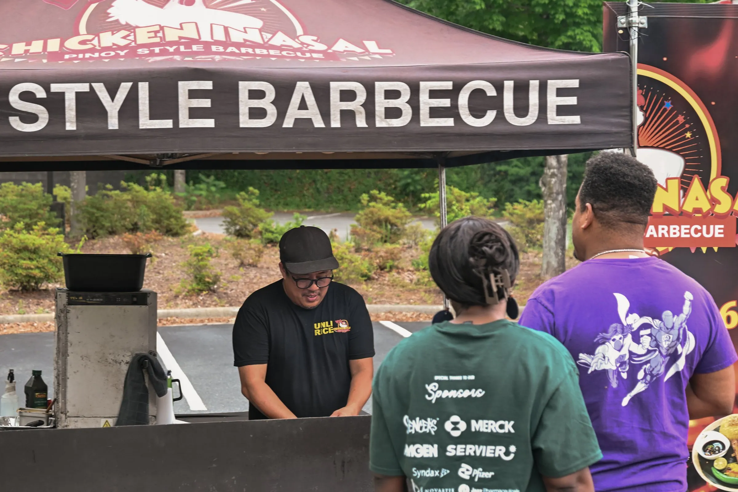 Customers lined up at the grill under the Pinoy Style Barbecue tent
